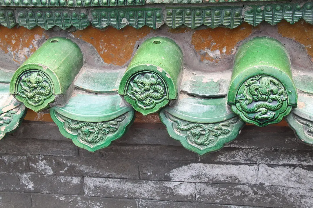 Green glazed roof tile ends decorated with dragons on a palace roof in Beijing